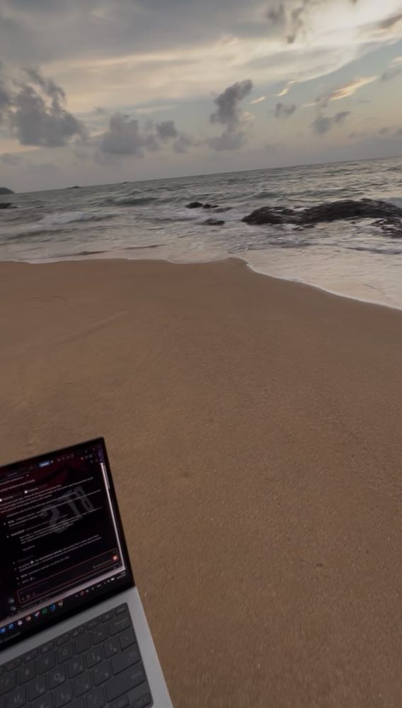 Laptop open on the sand at sunset