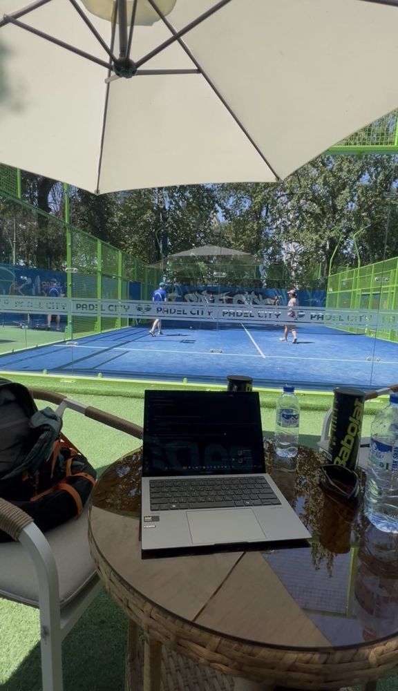 Laptop on a table courtside at a padel club