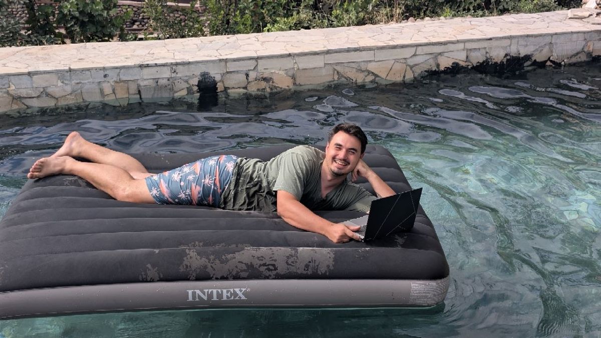 Working on a laptop on an inflatable mattress in a pool